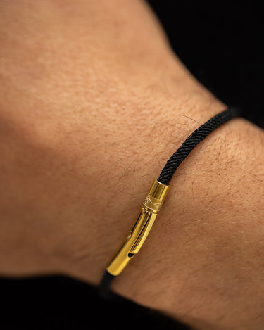 Noirèa Goudkleurig Zwart Armband 3mm op een pols, handgemaakte sieraden, luxe heren sieraden, premium kwaliteit.