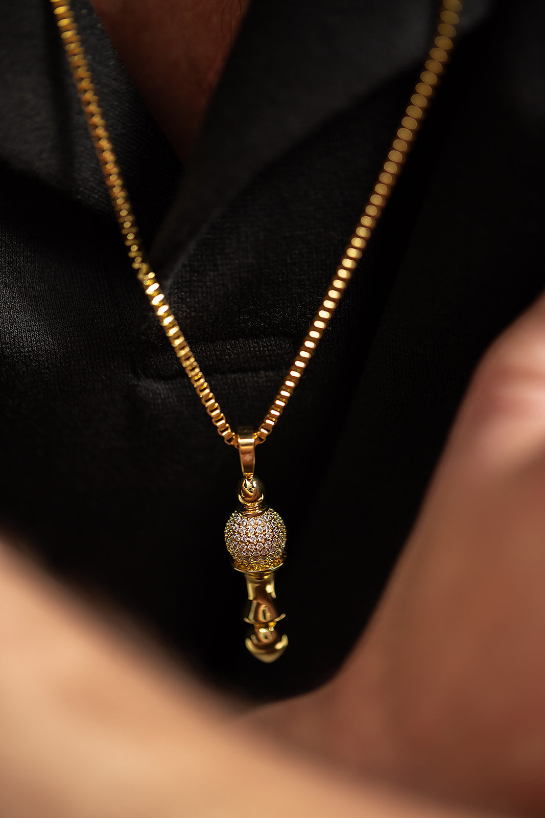Man draagt Divine Balance Goudkleurig Ketting met pavé en kristallen, luxe heren sieraden van Roanross, exclusief en handgemaakt.