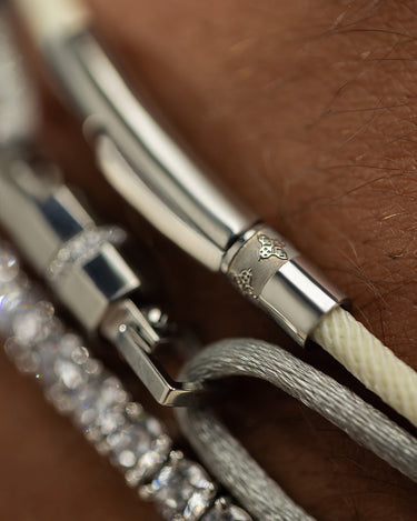 Detail van een luxueuze zilverkleurige armband met handgemaakte elementen en een elegante sluiting.