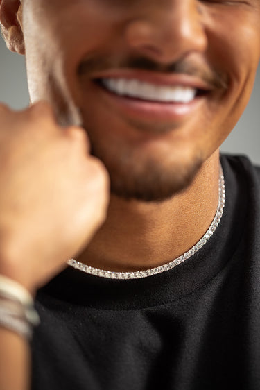 Crystal Embrace zilver Tennis Ketting, symbool van zuiverheid en sprankelende energie, gedragen door een man.