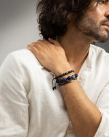 Man draagt een donkerblauwe armband met handgemaakte sieraden en luxe heren sieraden.