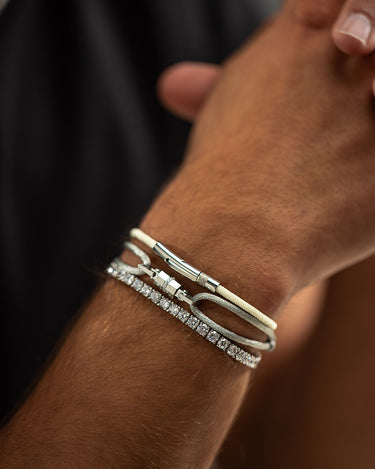 Man draagt handgemaakte luxe heren sieraden met een elegante armband en glitterdetails, premium kwaliteit exclusieve sieraden voor mannen.