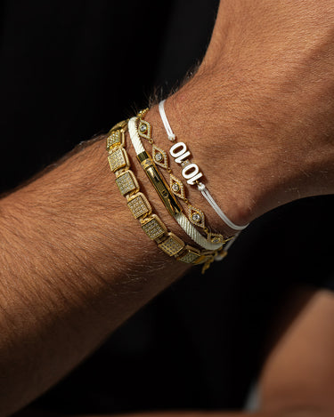 Close-up van een arm met unieke handgemaakte gouden herensieraden
